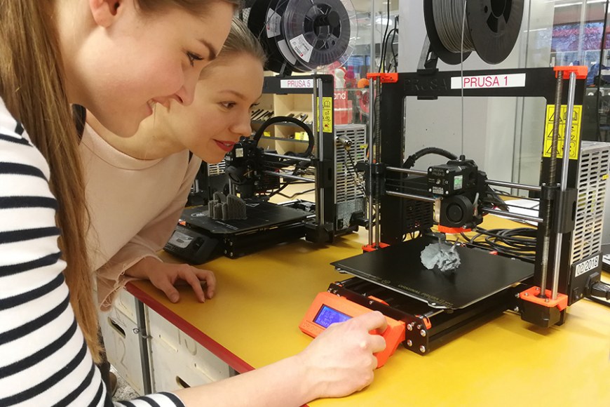 Kaksi tyttöä työskentee 3D-tulostimella.