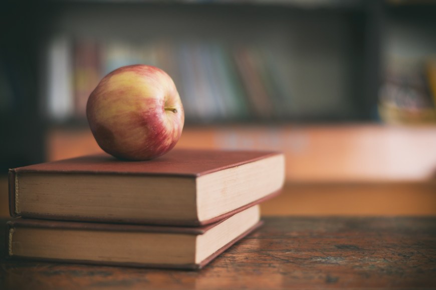 Two books and an apple on top