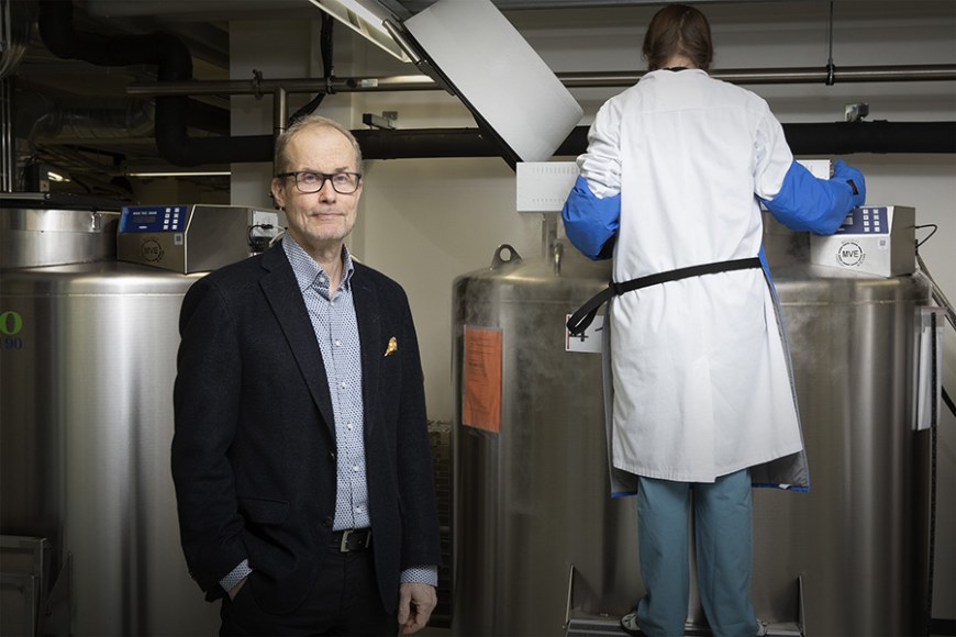 Professori Heikki Hyöty laboratoriossa. Takana laitteita ja toinen henkilö.