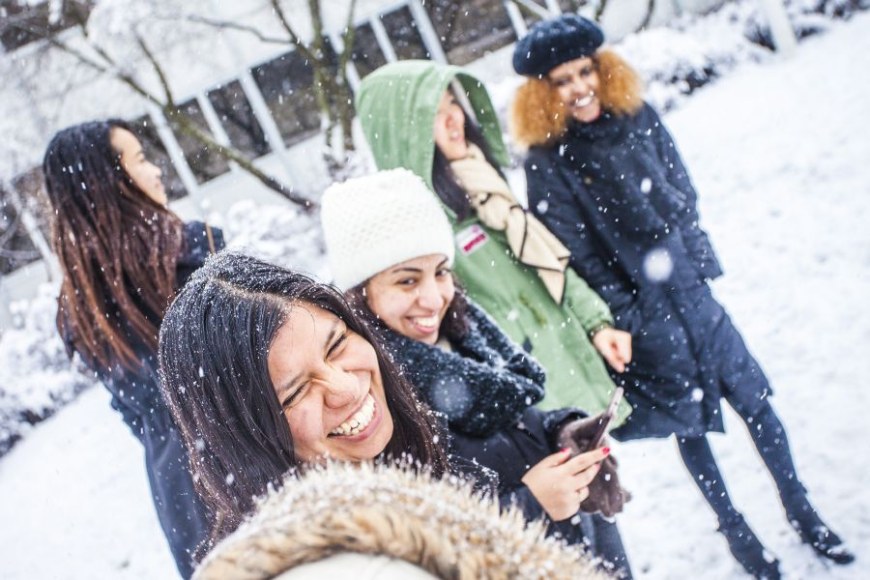 An international student group playing in snow.