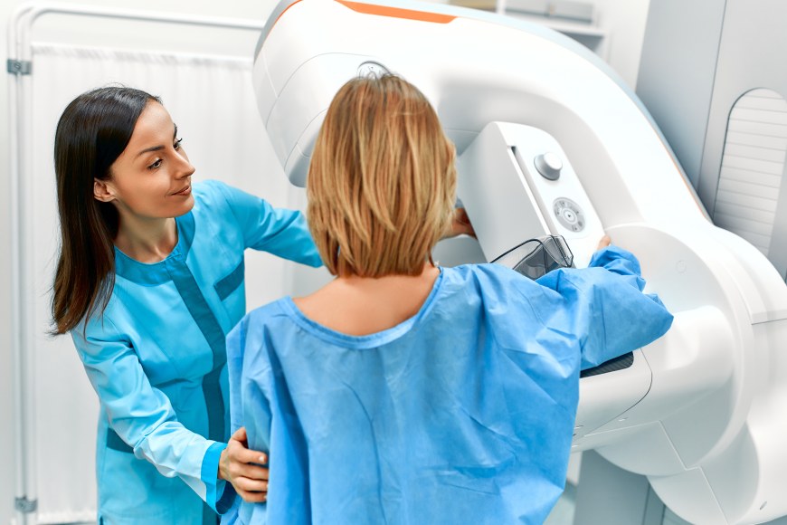 Asiakas ja hoitaja mammografialaitteella