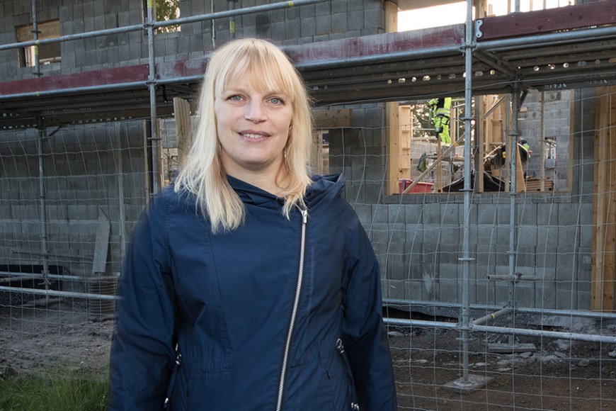TAMKin lehtori Katja Finnilä seisoo rakennustyömaalla.