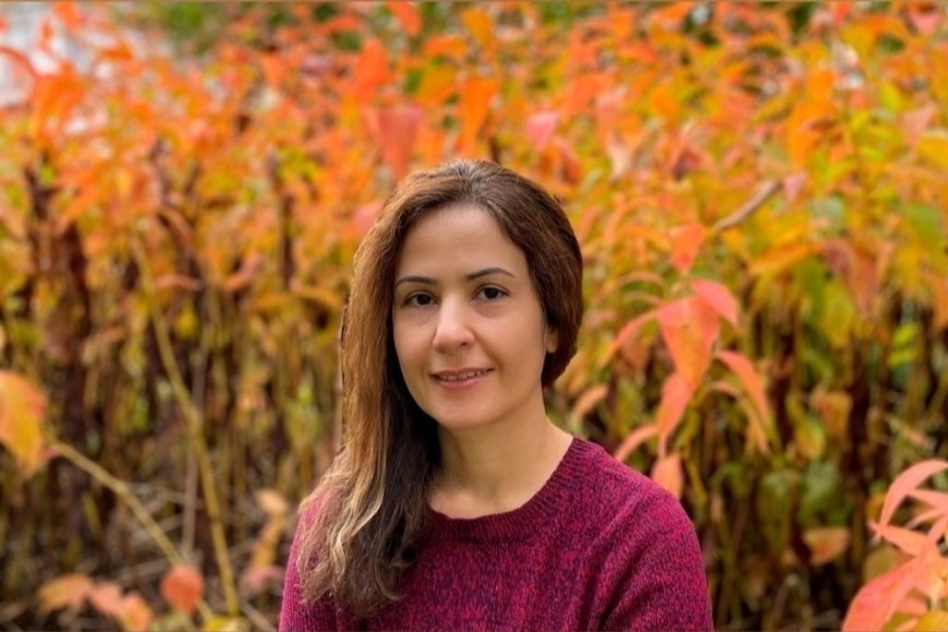 Doctoral researcher Golaleh Makrooni in front of a fall scenery.