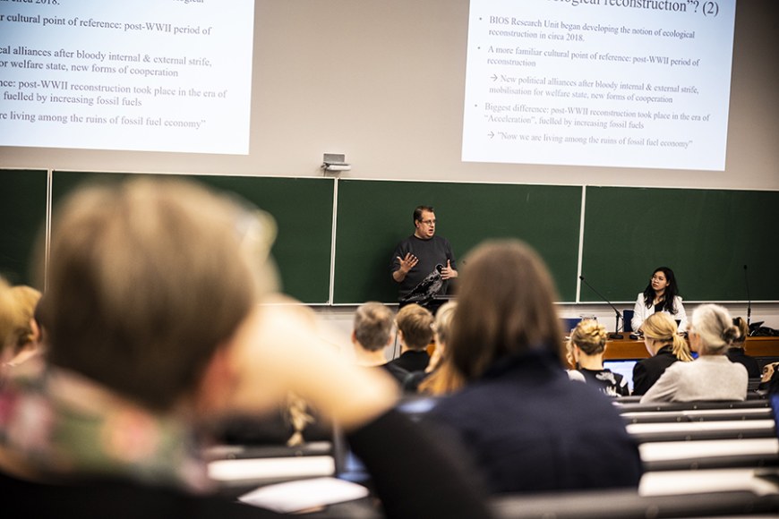 Tutkija Ville Lähde pitämässä seminaarin keynote-luentoa, yleisöä etualalla.