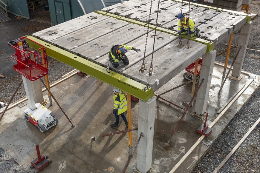 Purettavaksi suunnitelluista runko-osista rakennettua betonitaloa asennetaan työmaalla.