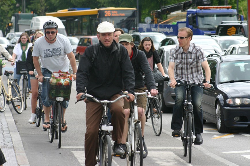Polkupäyröräilijöitä omalla kaistallaan autoliikenteen vieressä Kööpenhaminassa.