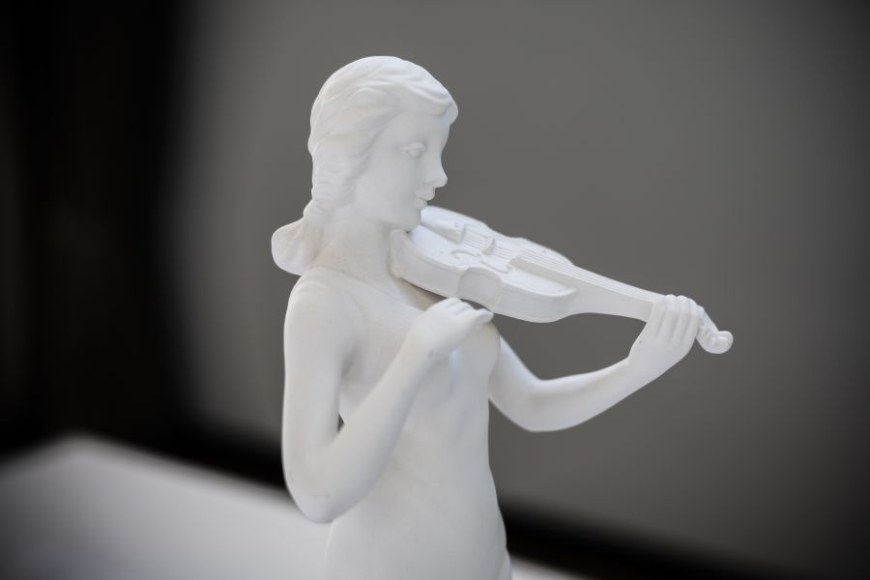 Pieni valkoinen kipsiveistos, joka esittää viulua soittavaa hahmoa.