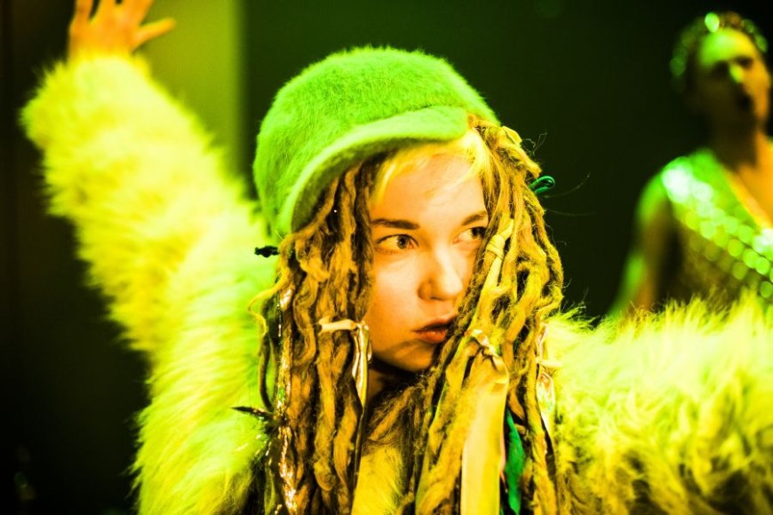 Rastatukkainen tyttö, jolla on keltainen asu,