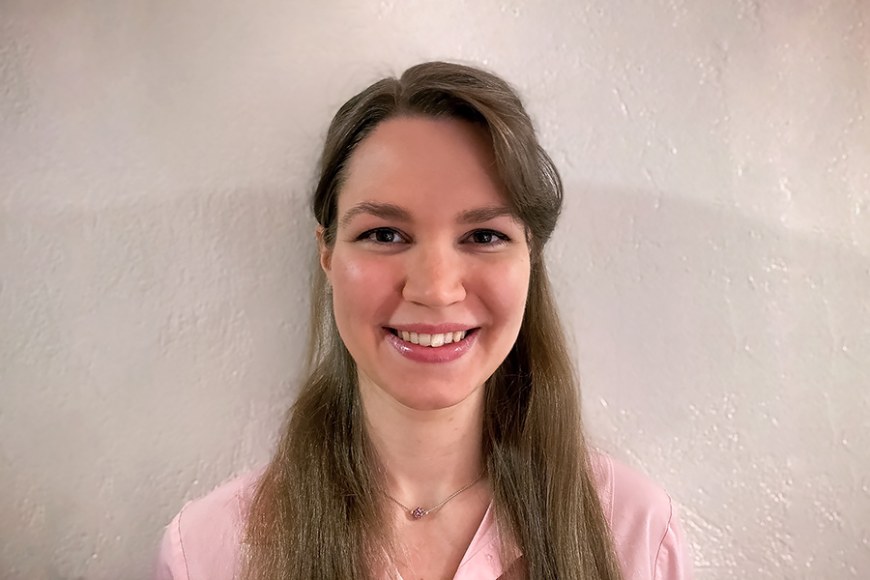 Potrettikuva Susanna Haapasesta, jolla on yllään vaaleanpunainen pusero. Taustalla on vaalea seinä.