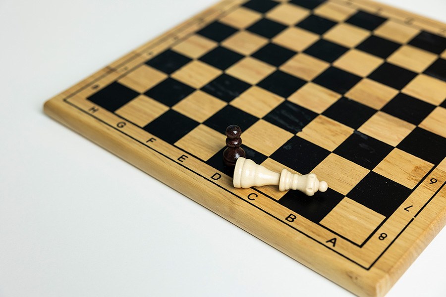 A soldier has taken the queens place on the chess board.