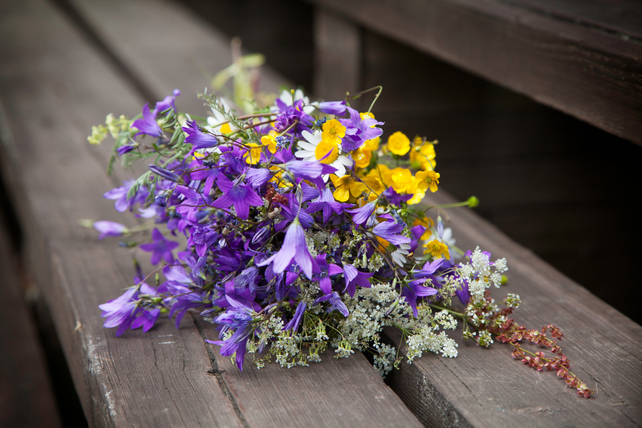 Luonnonkukkakimppu penkillä.