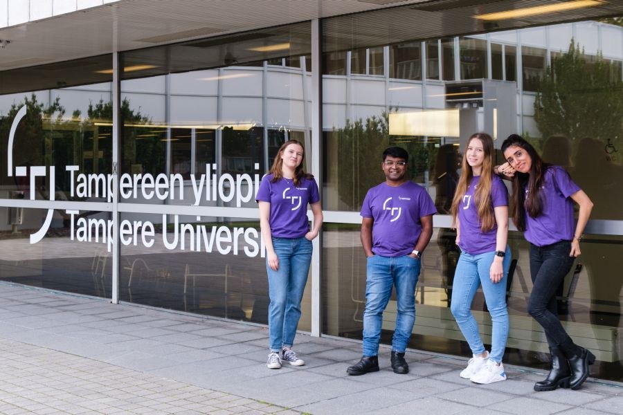 Students standing by the city centre campus main building entrance.