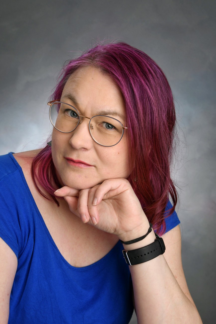 Potretti punahiuksisesta henkilöstä yllään sininen paita.