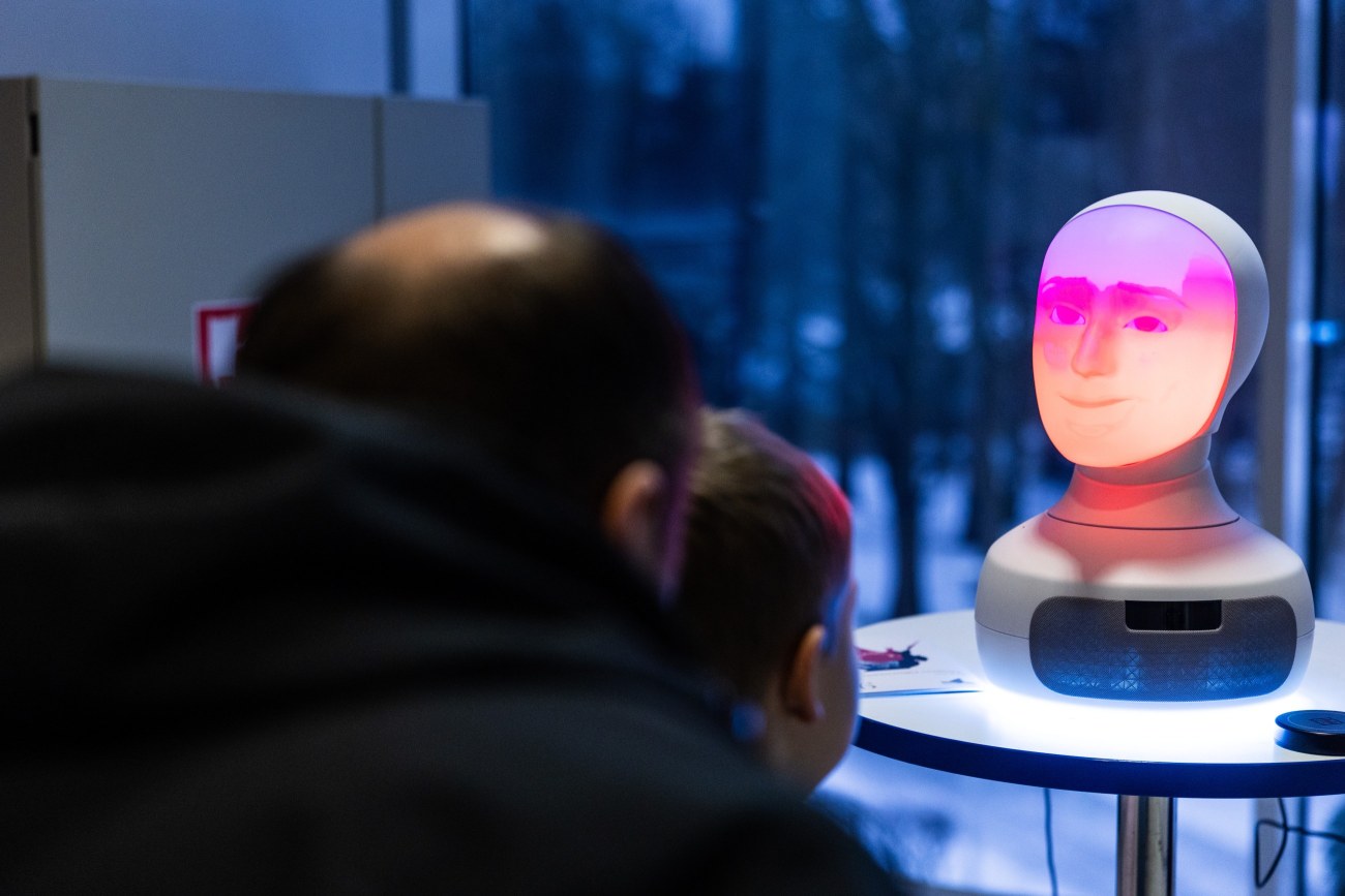 Lapsi ja aikuinen katsomassa robotin kasvoja.