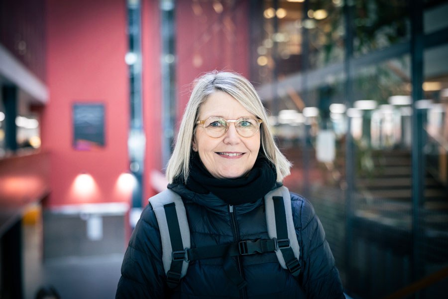 Sanna Keipilä Tampereen yliopiston Linna-rakennuksessa, katsoo kameraan.