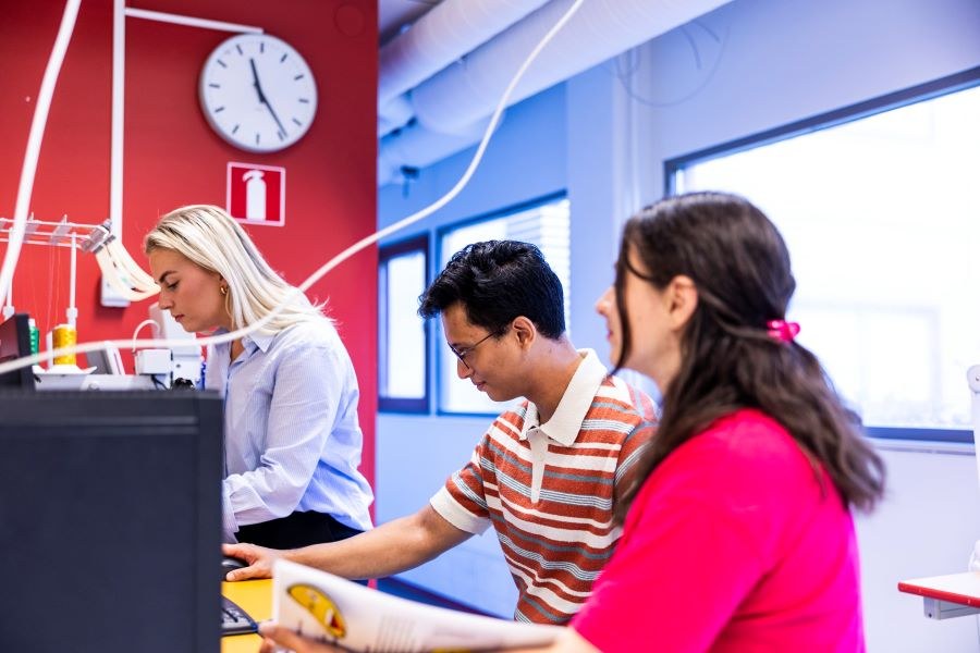 Kolme opiskelijaa työskentelevät yhdessä. 