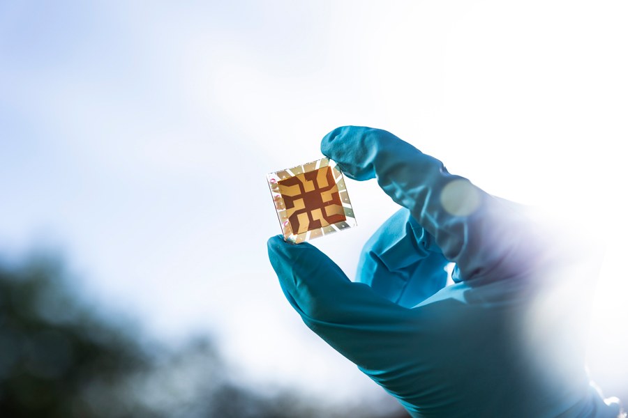 Protective gloved hand holding a solar cell.