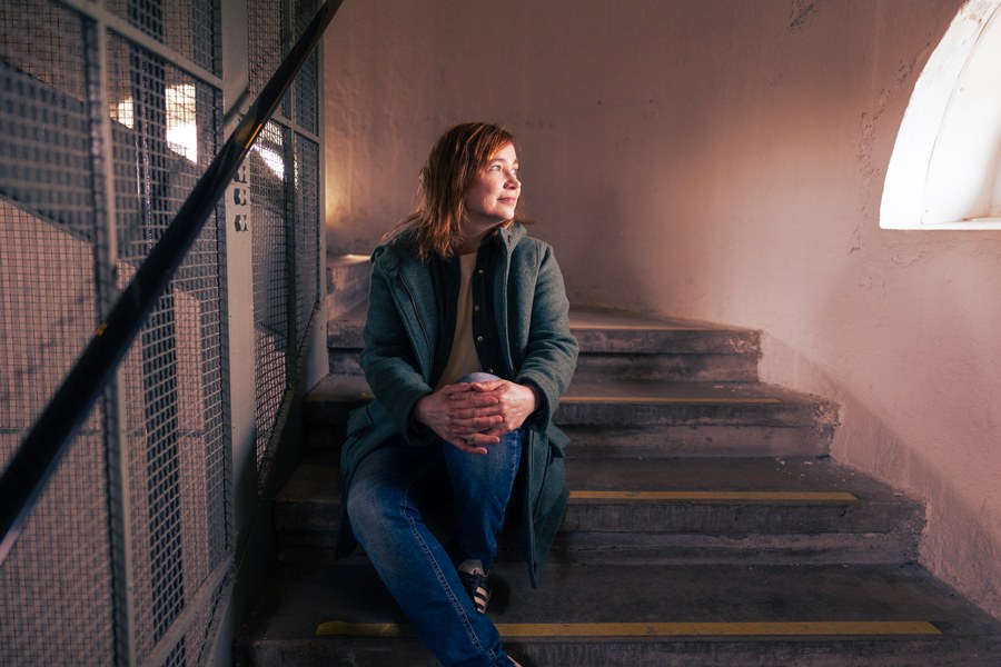 Helena Leino is sitting on the staircase, looking out of the window.