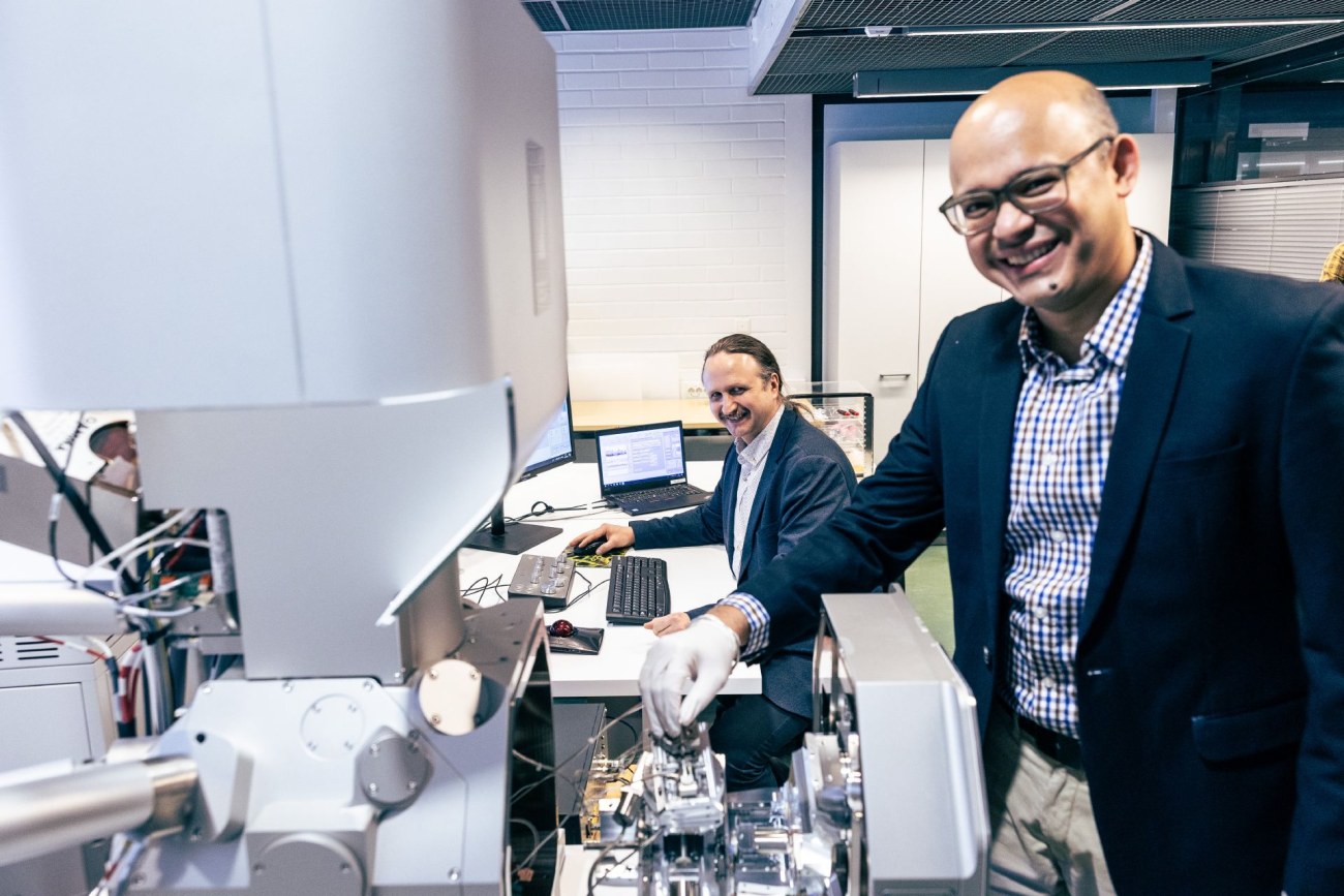 Two persons operating SEM and in-situ nanoindentation system