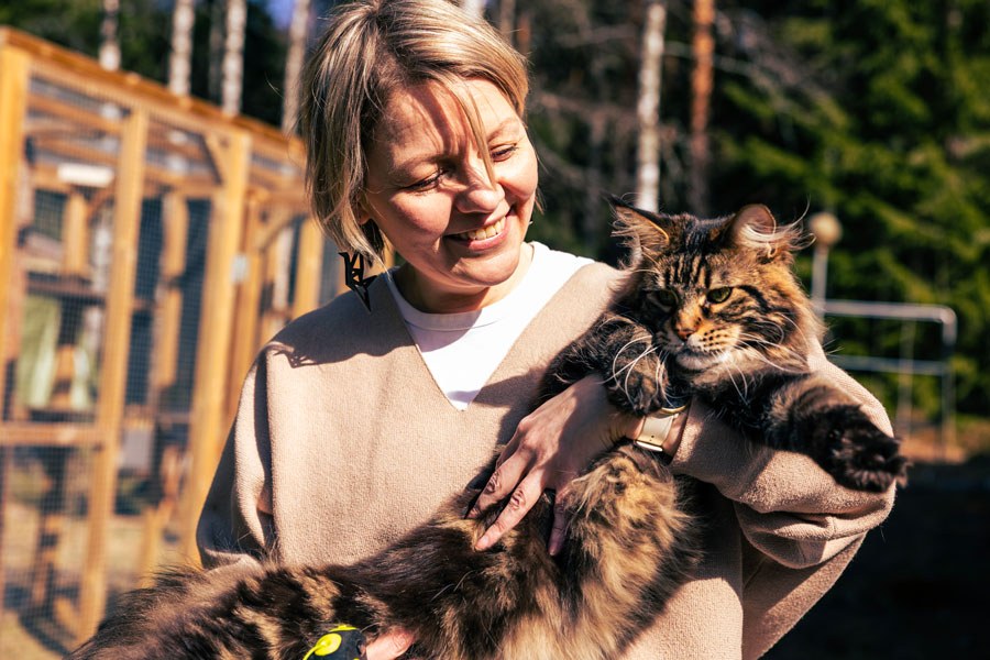 Sanna Kumpulainen sylissään kissa.