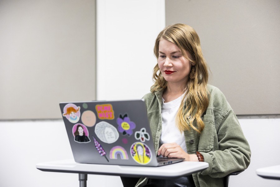 Opiskelija työskentelee kannettavalla tietokoneella seisovan pöydän ääressä.