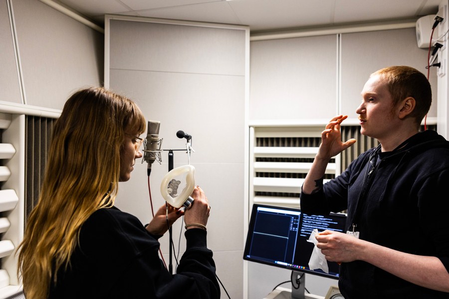 Kaksi henkilöä katsomassa äänimaskin käyttöä.