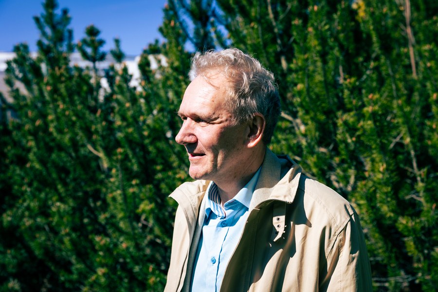 Klaus Ranta katsoo ulkona horisonttiin taustalla vehreää.