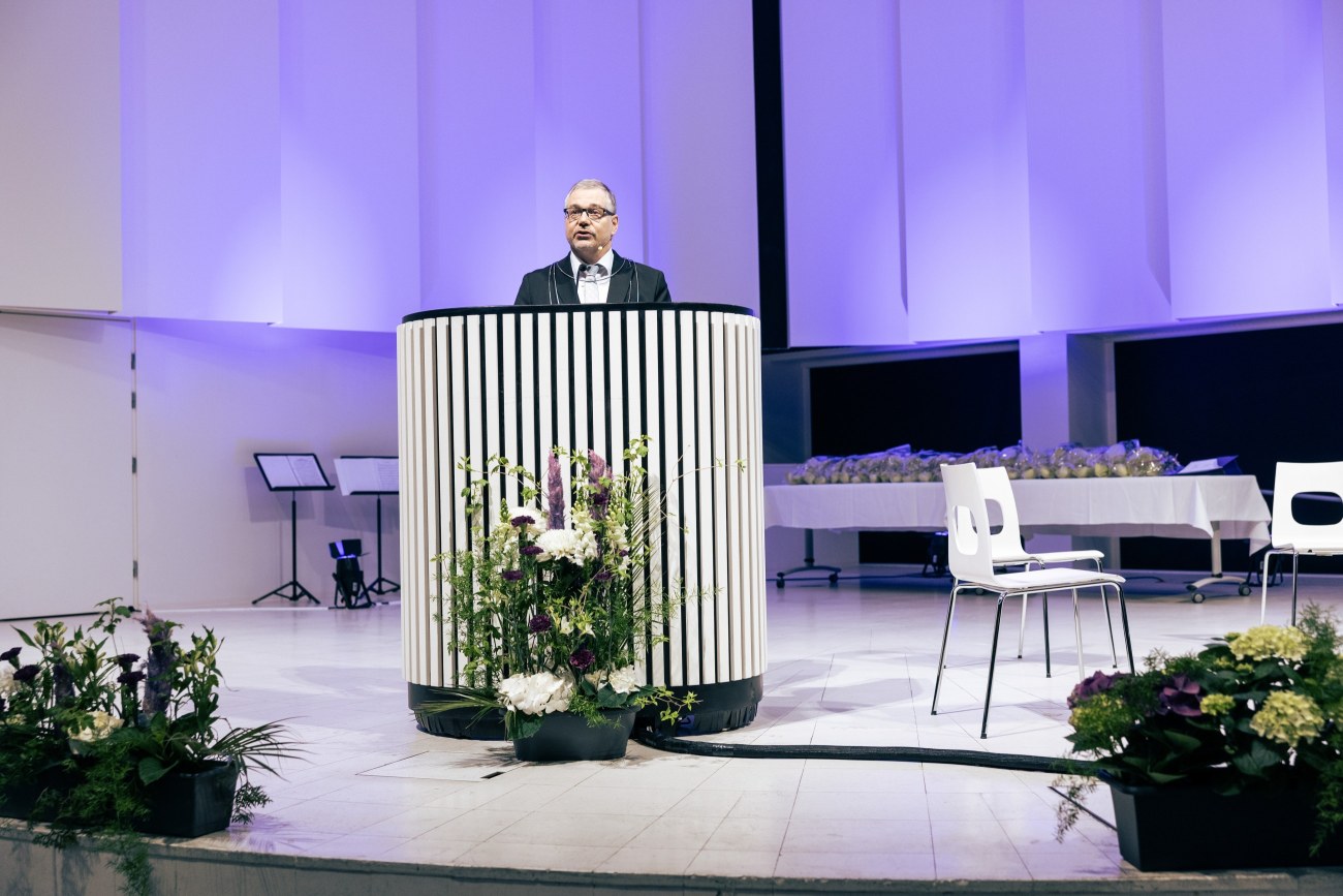 Rehtori Keijo Hämäläinen pitämässä puhetta juhlasalin lavalla.