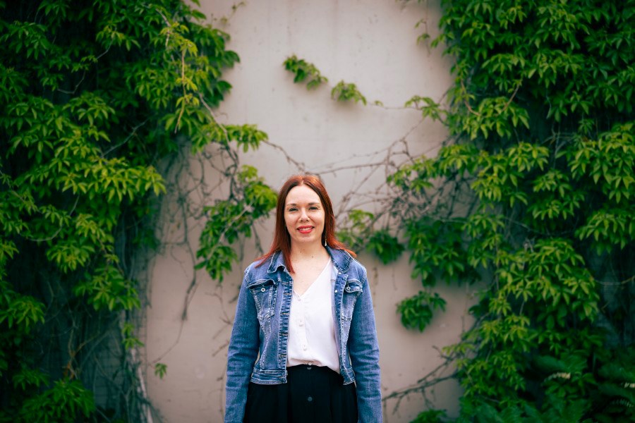 Hanna Ylöstalo looks at the camera in front of a vine.
