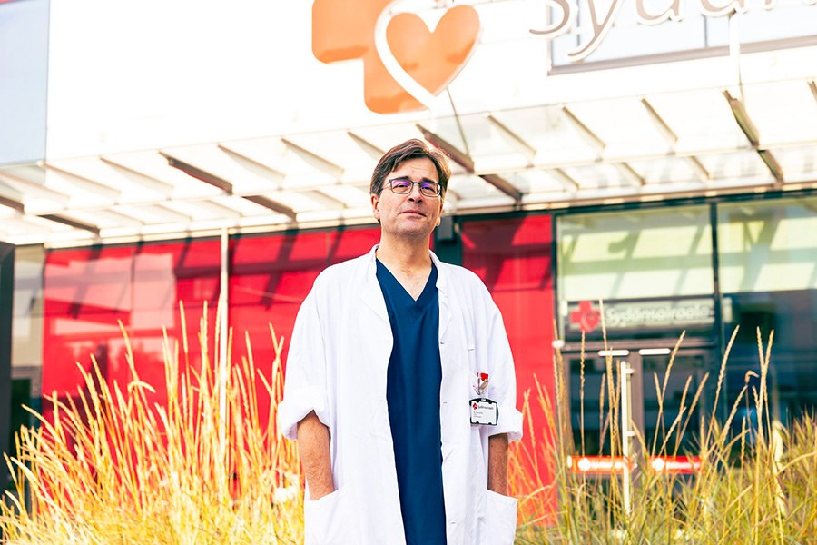 Ari Mennander standing in front of the Heart Hospital.