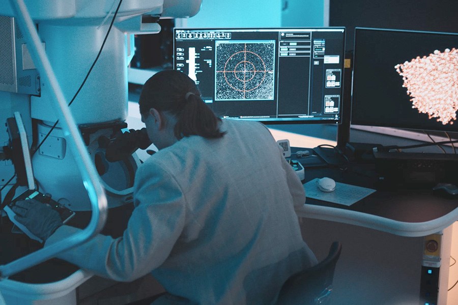 Tutkija tutkii joustavaa lasia Mikroskopiakeskuksessa.