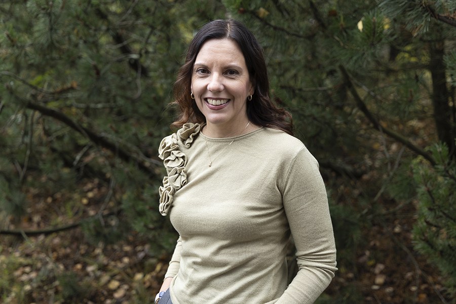 Nainen ulkona pukeutuneena beigeen puseroon.