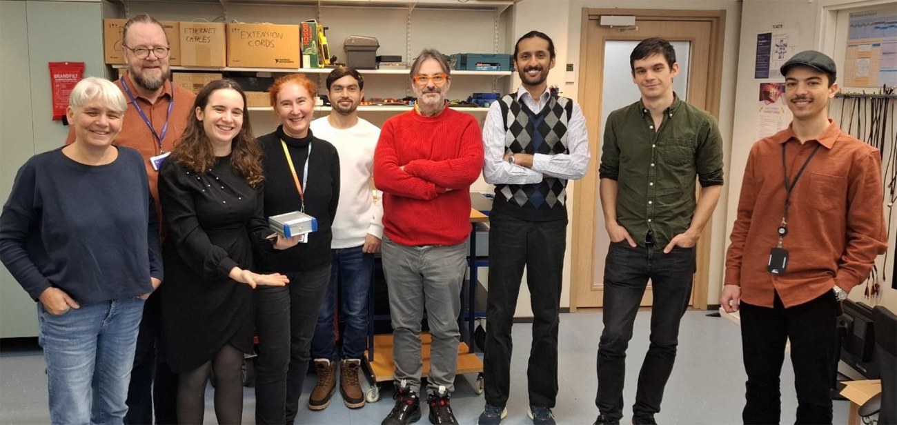 Group photo with the ROBOSAT participants in the EE-ITC lab, with the hand-held I/Q grabber device which will play a crucial role in the project.
