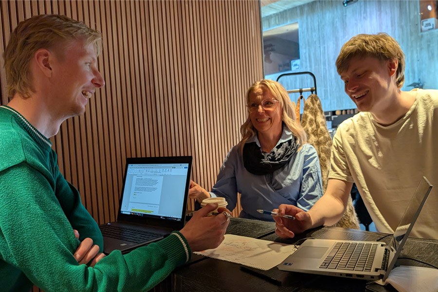 Kolme tutkijaa työpajailemassa, edessään tietokoneet ja muistiipanoja.