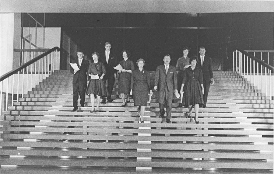 Ihmisiä mustavalkoisessa kuvassa yliopiston portaissa.