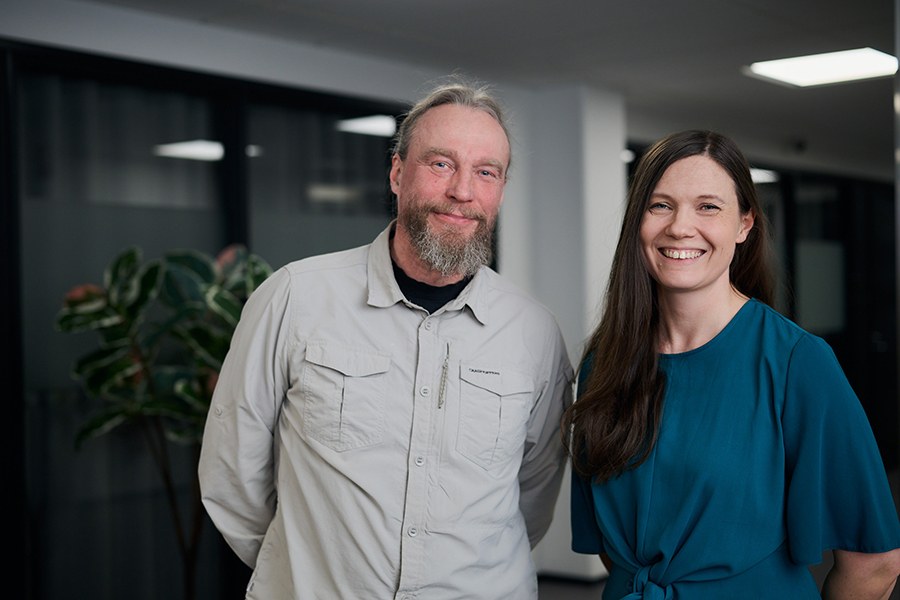 Mies ja nainen katsovat hymyillen kameraan.