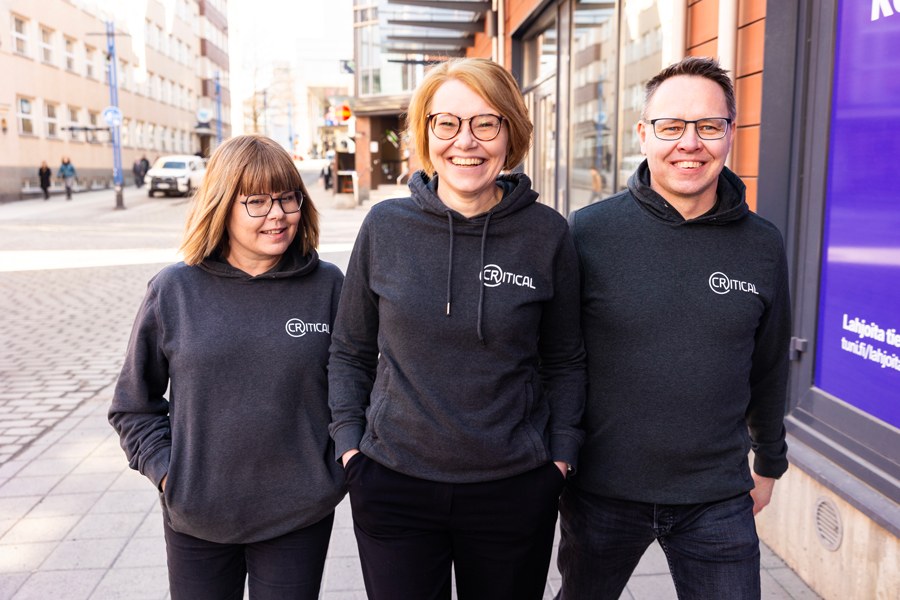 Kolme henkilöä ulkoilemassa hupparit päällä.