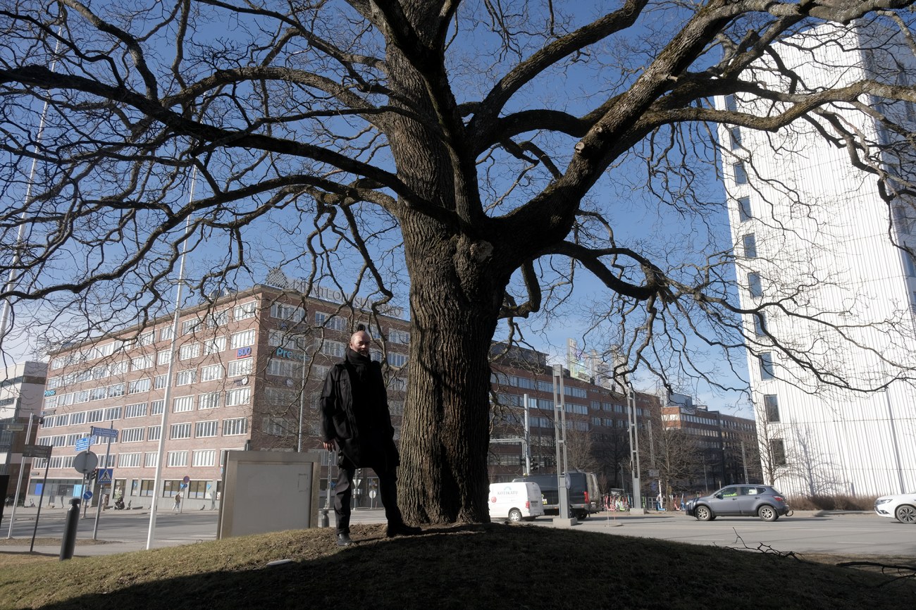 Frans Mäyrä seisoo puun vieressä Tampereen yliopiston keskustakampuksella
