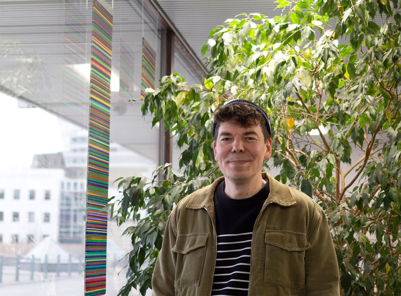 Jaakko Stenros seisoo Tampereen yliopiston päätalolla ikkunan vieressä.