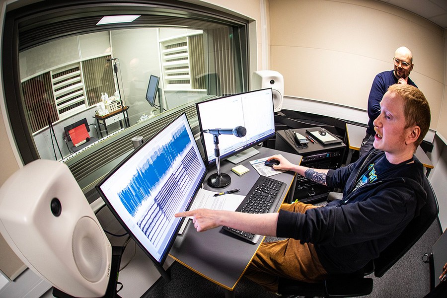 Kaksi henkilöä tarkkaamossa tietokoneen äärellä.