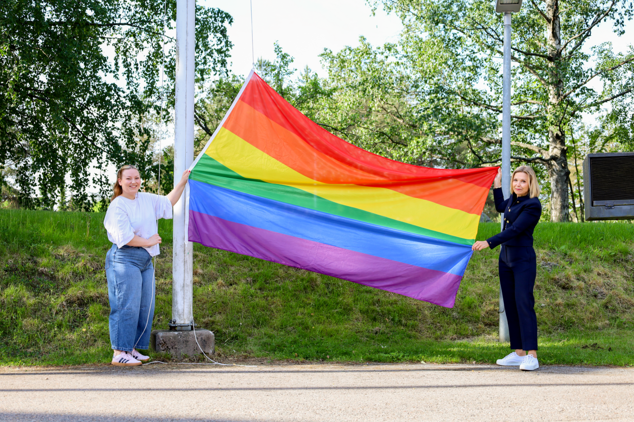 Saara Ahola ja Katja Komulainen pitelevät sateenkaarilippua.