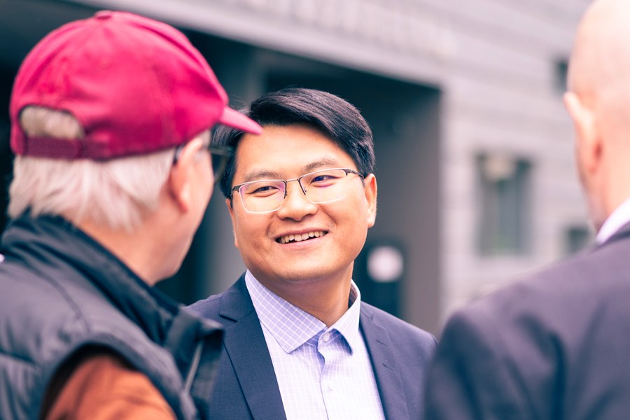 Chao He talking to colleagues on campus.