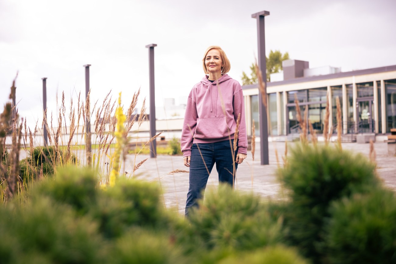Camilla Lindholm seisoo Tampereen yliopiston keskustakampuksen pihalla ja katsoo kameraan.
