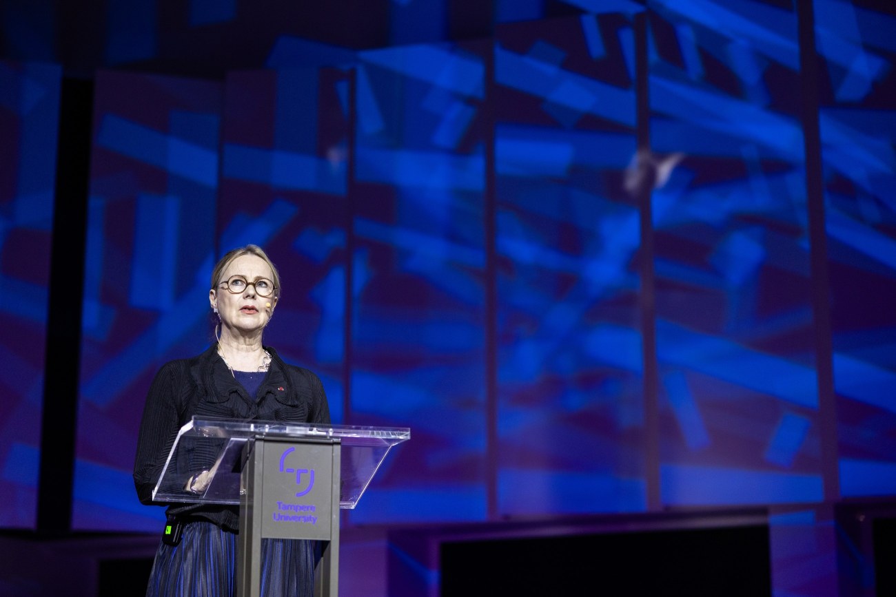 Susanna Pettersson seisoo puhujapöntön takana lavalla pitämässä puhetta.