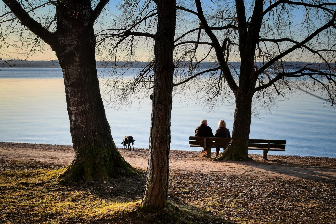 Kuva: Ikääntynyt pari istuu rannalla.