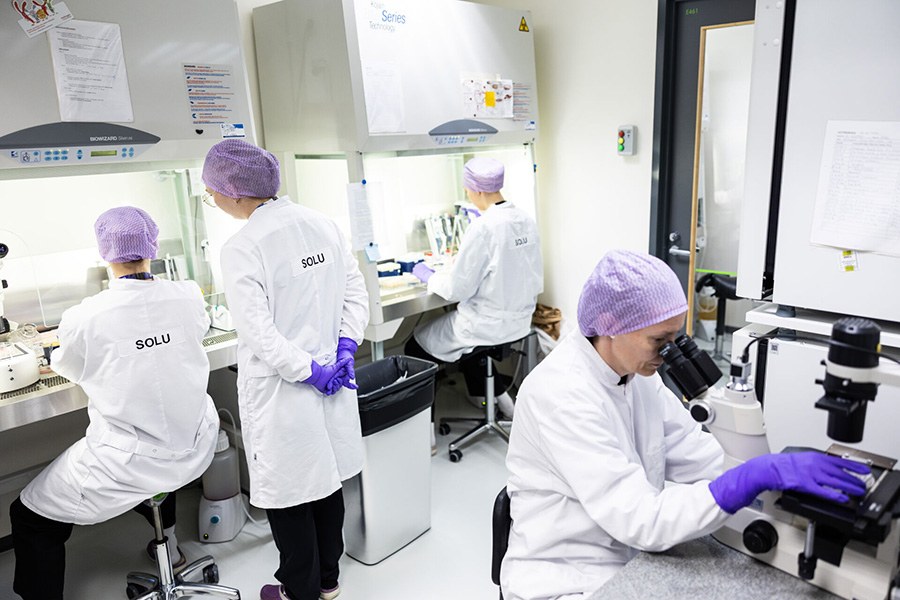 Valkoisiin takkeihin pukeutuneet ihmiset työskentelevät laboratoriossa.