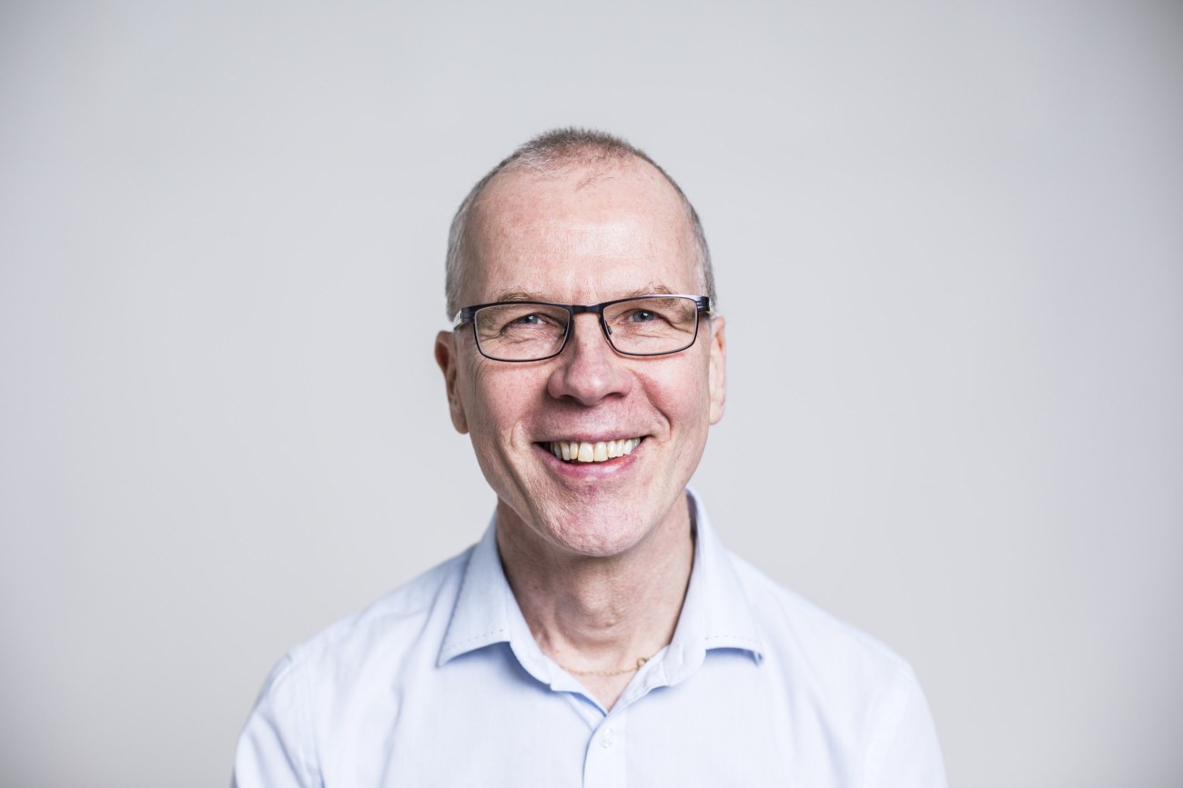 Studiovalokuva hymyilevästä Markku Ihosesta.