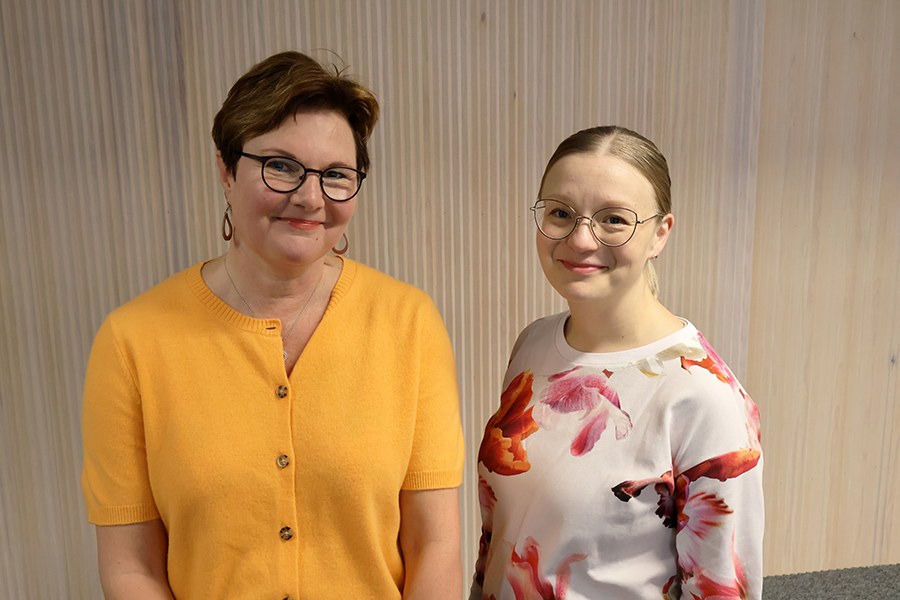 Kaksi hymyilevää naista lähikuvassa. 