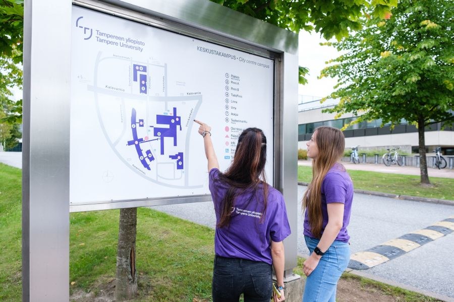 Study with us ambassadors checking campus map