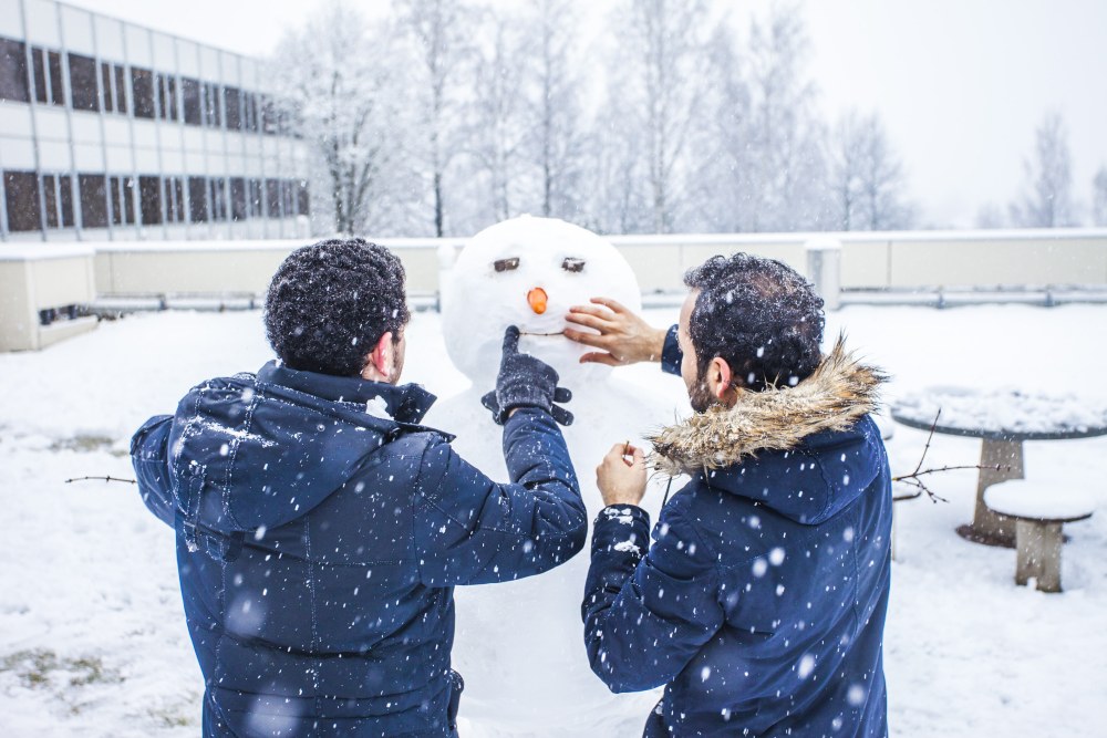 International students building a snowperson.